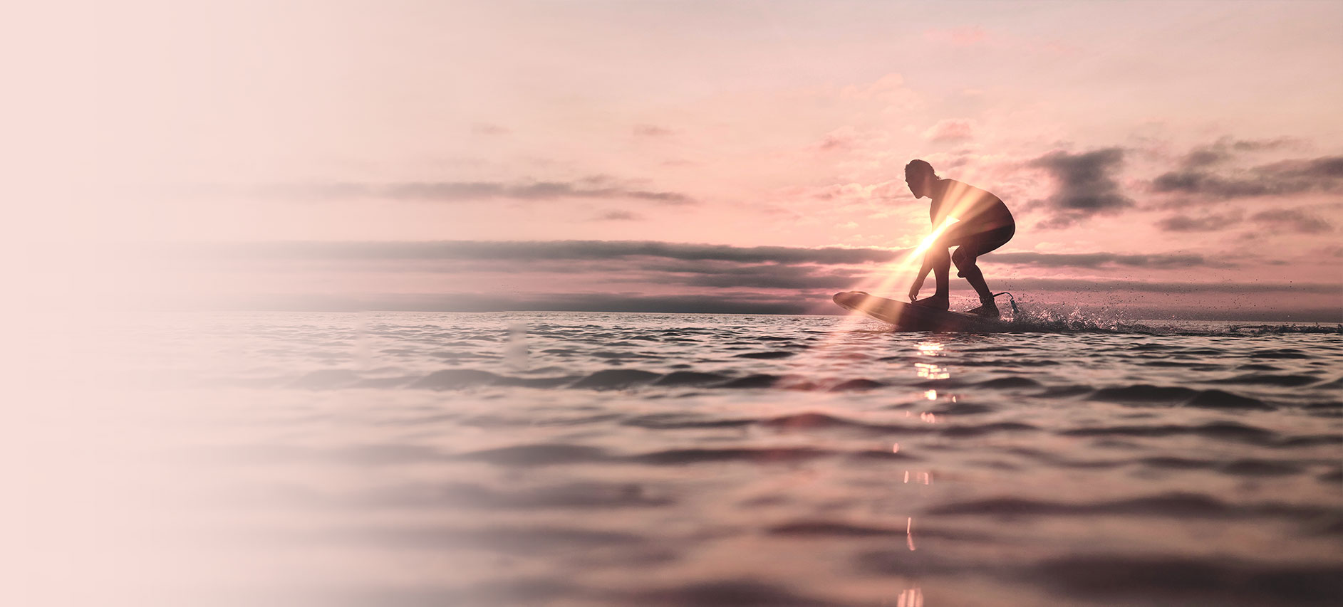 soleil levant avec un surfeur